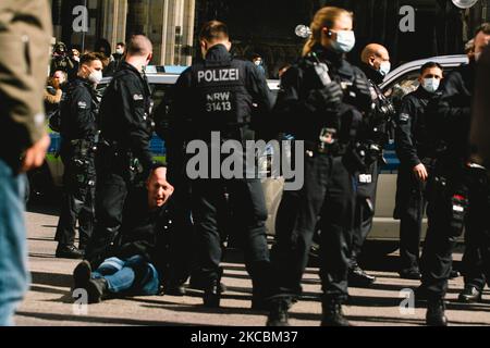 Les membres de la police arrêtent un homme sans masque facial qui participe à la manifestation devant la cathédrale de Cologne, en Allemagne, sur 27 mars 2021, alors que des centaines de coronavirus sceptiques prévoient de se réunir pour protester contre les restrictions concernant le coronavirus (photo de Ying Tang/NurPhoto). Banque D'Images