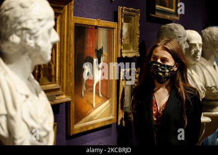 Un membre du personnel pose en regardant un tableau de l'archidogue française Millicent, la duchesse du premier chien de Sutherland en 1890s, par l'artiste britannique W. Cheesman, estimé à GBP1 000-1 500, lors d'un aperçu de presse pour la vente prochaine d'articles du château de Dunrobin en Écosse, Sous instruction du comte de Sutherland de 25th, à la maison de vente aux enchères de Bonhams à Londres, Angleterre, sur 30 mars 2021. La vente elle-même a lieu sur 20 avril à Édimbourg. (Photo de David Cliff/NurPhoto) Banque D'Images