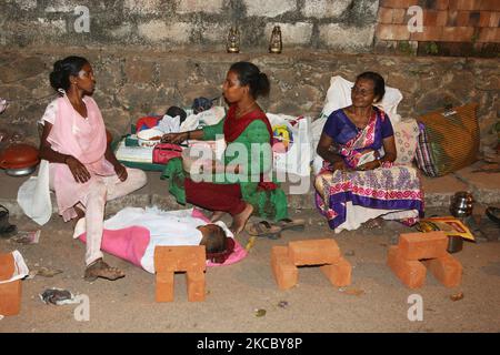 Des femmes hindoues s'assoient le long du bord de la route pendant la nuit pour s'assurer un lieu pour le lendemain matin pour cuisiner le pongala près du temple Attakal Bhagavathy la nuit du 9th jour du festival Attukal Pongala Mahotsavam de 10 jours dans la ville de Thiruvananthapuram (Trivandrum), Kerala, en Inde, sur 19 février 2019. Le festival Attukal Pongala Mahotsavam est célébré chaque année par des millions de femmes hindoues. Au cours de ce festival, les femmes préparent le Pongala (riz cuit avec des jaggery, ghee, noix de coco ainsi que d'autres ingrédients) à l'ouverture dans de petits pots pour plaire à la déesse Attukal Devi (populairement connu sous le nom d'Attukal Amma Banque D'Images