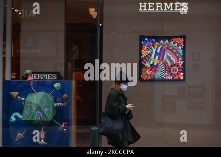 Une femme portant un masque de visage marche par Brown Thomas fenêtre avec des produits Hermes, à Dublin pendant le niveau 5 COVID-19 verrouillage. Le mercredi 7 avril 2021, à Dublin, Irlande. (Photo par Artur Widak/NurPhoto) Banque D'Images