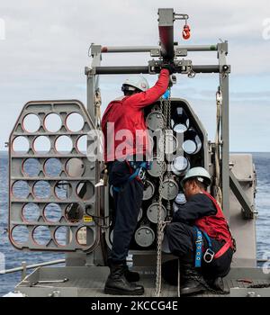 Fire Controlmen charge un missile dans un système de missile Airframe roulant RIM-116. Banque D'Images