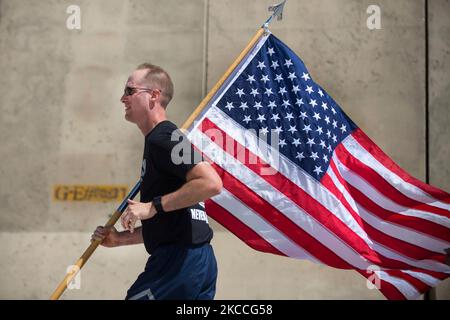 Le commandant de la US Air Force porte le drapeau américain tout en participant à une course. Banque D'Images