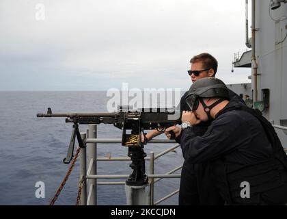 Aviation Boatswain's Mate tire une mitrailleuse de M240. Banque D'Images