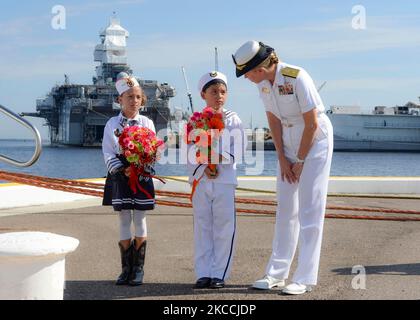 Le commandant de la marine américaine parle avec deux enfants de cérémonie. Banque D'Images