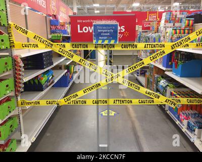 Le ruban de mise en garde jaune bloque les allées où des marchandises ne peuvent pas être vendues dans un magasin Walmart pendant la pandémie du nouveau coronavirus (COVID-19) à Toronto, Ontario, Canada, on 12 avril 2021. Le premier jour de la dernière commande de l'état d'urgence et de séjour à la maison de la COVID-19 en Ontario, les magasins à grande caisse ont été contraints d'adopter de nouvelles mesures pour bloquer les articles jugés non essentiels par le gouvernement provincial. La dernière commande a fermé les petits détaillants pour leurs achats en personne et leur a permis d'offrir uniquement le ramassage ou la livraison sur le trottoir. Cette fois-ci, cependant, les grands détaillants peuvent rester ouverts, mais seulement vendre des Banque D'Images