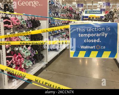 Le ruban de mise en garde jaune bloque les allées où des marchandises ne peuvent pas être vendues dans un magasin Walmart pendant la pandémie du nouveau coronavirus (COVID-19) à Toronto, Ontario, Canada, on 12 avril 2021. Le premier jour de la dernière commande de l'état d'urgence et de séjour à la maison de la COVID-19 en Ontario, les magasins à grande caisse ont été contraints d'adopter de nouvelles mesures pour bloquer les articles jugés non essentiels par le gouvernement provincial. La dernière commande a fermé les petits détaillants pour leurs achats en personne et leur a permis d'offrir uniquement le ramassage ou la livraison sur le trottoir. Cette fois-ci, cependant, les grands détaillants peuvent rester ouverts, mais seulement vendre des Banque D'Images