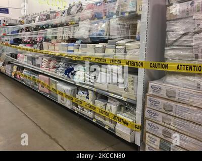 Le ruban de mise en garde jaune bloque les allées où des marchandises ne peuvent pas être vendues dans un magasin Walmart pendant la pandémie du nouveau coronavirus (COVID-19) à Toronto, Ontario, Canada, on 12 avril 2021. Le premier jour de la dernière commande de l'état d'urgence et de séjour à la maison de la COVID-19 en Ontario, les magasins à grande caisse ont été contraints d'adopter de nouvelles mesures pour bloquer les articles jugés non essentiels par le gouvernement provincial. La dernière commande a fermé les petits détaillants pour leurs achats en personne et leur a permis d'offrir uniquement le ramassage ou la livraison sur le trottoir. Cette fois-ci, cependant, les grands détaillants peuvent rester ouverts, mais seulement vendre des Banque D'Images