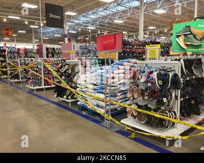 Le ruban de mise en garde jaune bloque les allées où des marchandises ne peuvent pas être vendues dans un magasin Walmart pendant la pandémie du nouveau coronavirus (COVID-19) à Toronto, Ontario, Canada, on 12 avril 2021. Le premier jour de la dernière commande de l'état d'urgence et de séjour à la maison de la COVID-19 en Ontario, les magasins à grande caisse ont été contraints d'adopter de nouvelles mesures pour bloquer les articles jugés non essentiels par le gouvernement provincial. La dernière commande a fermé les petits détaillants pour leurs achats en personne et leur a permis d'offrir uniquement le ramassage ou la livraison sur le trottoir. Cette fois-ci, cependant, les grands détaillants peuvent rester ouverts, mais seulement vendre des Banque D'Images