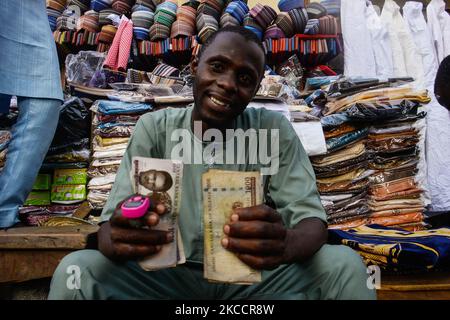 Un marchand de rue affiche une note de 1000 à l'entrée de la mosquée centrale de Lagos (île de Lagos) située le long de la rue animée Nnamdi Azikiwe de Lagos, Nigeria, 14 avril 2021. Les musulmans ont marqué le début du ramadan mardi, le ramadan est marqué par de longues prières, le jeûne au crépuscule et des fêtes nocturnes avec la famille et les amis, bien que le rassemblement de l'épaule à l'épaule dans la mosquée et le grand rassemblement pour les repas restent interdits en raison de la propagation continue de COVID-19. (Photo par Olukayode Jaiyeola/NurPhoto) Banque D'Images
