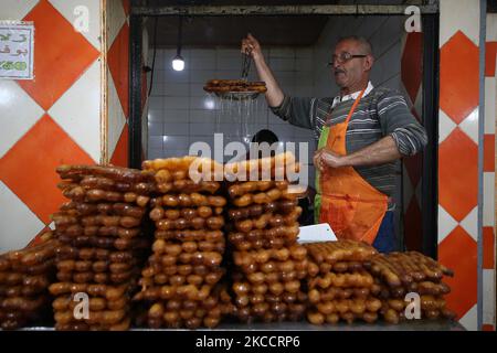 Un homme d'Algérie vend un dessert spécial appelé 'zalabia' et du jus de citron dans une pâtisserie à Boufarik, Algérie, 15 avril 2021. Zalabiya est le dessert le plus populaire pendant le mois Saint du Ramadan en Algérie. Il est mangé comme un dessert spécial. Après le petit déjeuner. Les musulmans du monde entier célèbrent le mois béni du Ramadan en priant la nuit et en s'abstenant de manger et de boire entre le lever et le coucher du soleil. Le Ramadan est le neuvième mois du calendrier islamique. (Photo de Billal Bensalem/NurPhoto) Banque D'Images