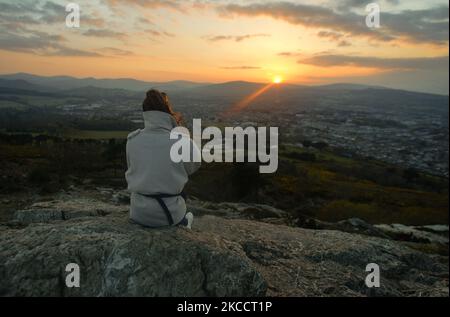 Une femme s'asseoir près du sommet de Bray Head au coucher du soleil, pendant le verrouillage COVID-19. Le jeudi 15 avril 2021, à Bray, comté de Wicklow, Irlande. (Photo par Artur Widak/NurPhoto) Banque D'Images