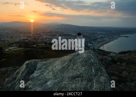 Une femme s'asseoir près du sommet de Bray Head au coucher du soleil, pendant le verrouillage COVID-19. Le jeudi 15 avril 2021, à Bray, comté de Wicklow, Irlande. (Photo par Artur Widak/NurPhoto) Banque D'Images