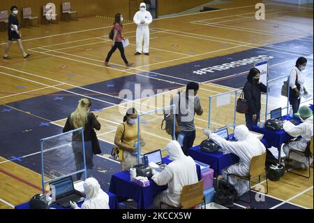 Les travailleurs médicaux portant des EPI enregistrent les personnes lors d'un test par écouvillonnage nasal pour le COVID-19 dans le but d'arrêter la nouvelle vague de la pandémie du coronavirus dans un complexe sportif à Bangkok, en Thaïlande, le 17 avril 2021. (Photo par Anusak Laowilas/NurPhoto) Banque D'Images