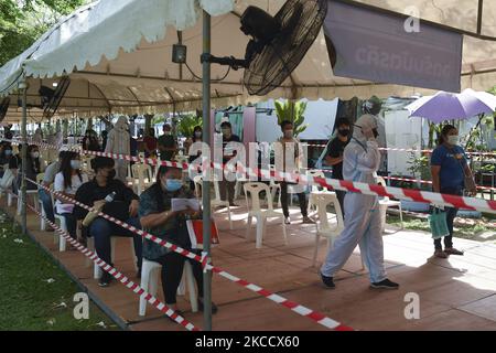 Les gens s'assoient dans la ligne pour se faire tester par écouvillonnage nasal pour le COVID-19 dans le but d'arrêter la nouvelle vague de la pandémie du coronavirus dans un complexe sportif à Bangkok, en Thaïlande, le 17 avril 2021. (Photo par Anusak Laowilas/NurPhoto) Banque D'Images