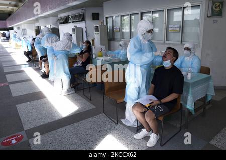 Un travailleur médical portant un EPI effectue un test par écouvillonnage pour le COVID-19 chez un homme lors d'un test par écouvillonnage nasal pour le COVID-19 dans le but d'arrêter la nouvelle vague de pandémie du coronavirus dans un complexe sportif de Bangkok, Thaïlande, 17 avril 2021. (Photo par Anusak Laowilas/NurPhoto) Banque D'Images