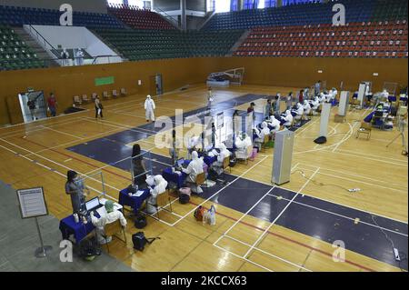 Les travailleurs médicaux portant des EPI enregistrent les personnes lors d'un test par écouvillonnage nasal pour le COVID-19 dans le but d'arrêter la nouvelle vague de la pandémie du coronavirus dans un complexe sportif à Bangkok, en Thaïlande, le 17 avril 2021. (Photo par Anusak Laowilas/NurPhoto) Banque D'Images