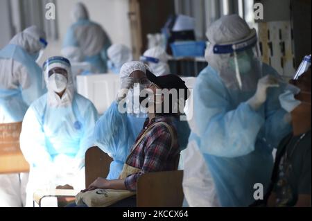 Un travailleur médical portant un EPI effectue un test par écouvillonnage pour le COVID-19 chez une femme lors d'un test par écouvillonnage nasal pour le COVID-19 dans le but d'arrêter la nouvelle vague de pandémie du coronavirus dans un complexe sportif de Bangkok, Thaïlande, 17 avril 2021. (Photo par Anusak Laowilas/NurPhoto) Banque D'Images