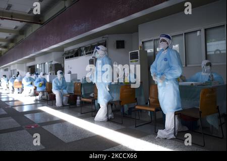 Un travailleur médical portant un EPI avant de procéder à un test par écouvillonnage pour le COVID-19 un effort pour arrêter la nouvelle vague de la pandémie du coronavirus dans un complexe sportif à Bangkok, Thaïlande, 17 avril 2021. (Photo par Anusak Laowilas/NurPhoto) Banque D'Images