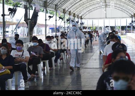 Les gens s'assoient dans la ligne pour se faire tester par écouvillonnage nasal pour le COVID-19 dans le but d'arrêter la nouvelle vague de la pandémie du coronavirus dans un complexe sportif à Bangkok, en Thaïlande, le 17 avril 2021. (Photo par Anusak Laowilas/NurPhoto) Banque D'Images
