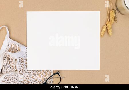 Feuille blanche vierge sur fond beige, papeterie, maquette papier, vue du dessus Banque D'Images