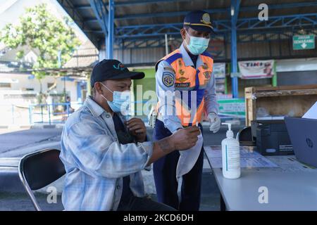 Un officier a effectué un test d'échantillon d'un passager à l'aide de l'outil GeNose C19 sur 22 avril 2021 au terminal de bus de Tingkir, à Salatiga, en Indonésie. Ce service d'essai gratuit GeNose C19 vise à détecter et à anticiper la transmission de Covid-19 dans les transports publics. (Photo par Galih Yoga/NurPhoto) Banque D'Images