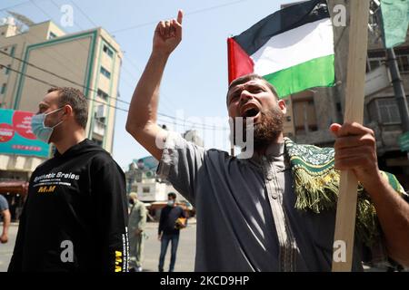 Les Palestiniens brandissent des slogans lors d'un rassemblement pour montrer leur solidarité avec les Palestiniens qui se sont affrontés avec les troupes israéliennes dans l'est de Jérusalem, dans la ville de Gaza, sur 23 avril 2021 - plus de 100 Palestiniens et 20 policiers israéliens ont été blessés lors d'affrontements nocturnes dans l'est de Jérusalem, annexe, a déclaré les autorités. Les violences ont éclaté à l'extérieur d'une entrée dans la vieille ville fortifiée, après que la police ait interdit l'accès à certaines zones où les Palestiniens se rassemblent généralement en grand nombre pendant le mois à jeun des musulmans du Ramadan. Les tensions ont été alimentées par l'arrivée des Juifs d'extrême-droite à la fin d'une marche au cours de laquelle ils ont harcelé Banque D'Images