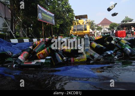 Le 23 avril 2021, le gouvernement de la région de Djakarta a détruit des boissons alcoolisées, dont plusieurs marques se sont déposées au bureau de police du secteur de Pulogadung, à Jakarta, en Indonésie. Des milliers de bouteilles d'alcool de différentes marques ont été détruites par des équipements lourds. Des boissons ont été obtenues d'une opération conjointe des autorités au cours des deux mois où elles ont subi des raids qui ont causé des pertes sociales à la communauté.(photo de Dasril Roszandi/NurPhoto) Banque D'Images