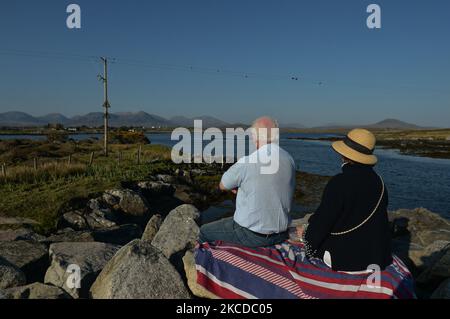 Un couple bénéficie d'une belle vue près du pont à Inishnee, pendant le confinement de la COVID-19. Le samedi 24 avril 2021, à Roundstone, Connemara, comté de Galway, Irlande. (Photo par Artur Widak/NurPhoto) Banque D'Images