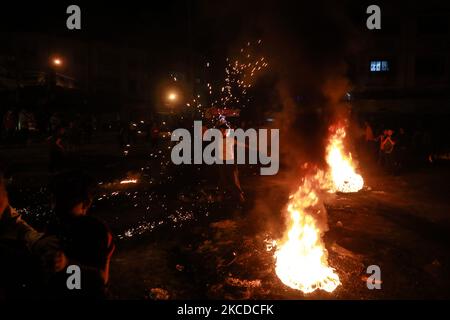 Les Palestiniens scandent des slogans alors qu'ils brûlent des pneus lors d'un rassemblement en faveur des manifestants à Jérusalem, à 24 avril 2021, dans la ville de Gaza. (Photo de Majdi Fathi/NurPhoto) Banque D'Images