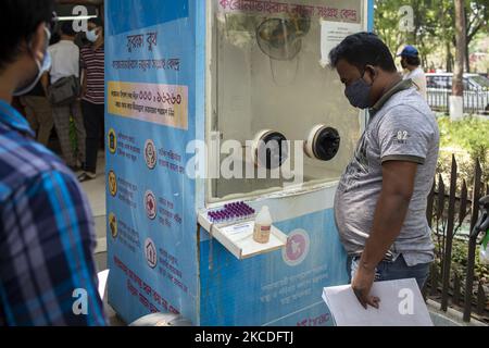 Un échantillon de test Covid 19 est resté en plein air et un homme regarde les échantillons à Dhaka, au Bangladesh, sur 25 mars 2021. (Photo par Istiak Karim/NurPhoto) Banque D'Images