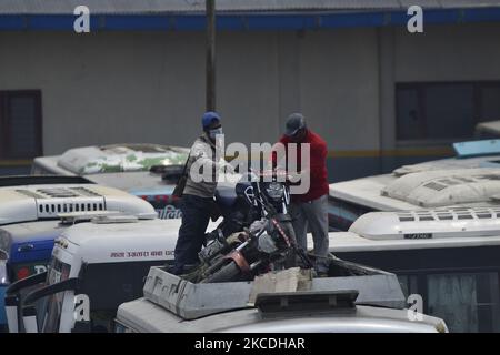 Les travailleurs népalais qui organisent des motards dans le toit d'un bus à Balaju, Katmandou, Népal, mardi, 27 avril 2021. Les gens commencent à quitter la vallée de Katmandou comme préoccupations du gouvernement sur le point de mettre en œuvre l'ordre d'interdiction de 15 jours de 29 avril, en raison de la propagation inclinée du virus Corona (COVID-19). (Photo de Narayan Maharajan/NurPhoto) Banque D'Images