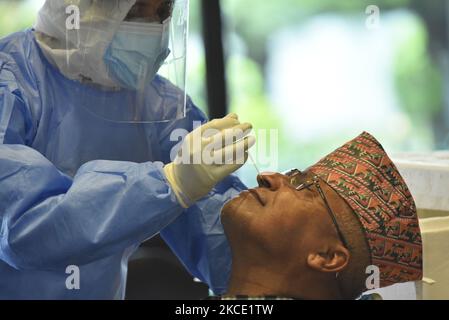 Un personnel de santé népalais recueille un échantillon de prélèvement nasal du ministre de l'éducation, des Sciences et de la technologie Krishna Gopal Shrestha pour un test PCR du coronavirus en tant que premier ministre pour demander un vote de confiance demandé mercredi par le président Bidya Devi Bhandari au Parlement fédéral, à Katmandou, au Népal, à 05 mai 2021. (Photo de Narayan Maharajan/NurPhoto) Banque D'Images