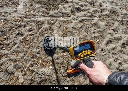 Un détectériste à la recherche de pièces de monnaie et de bijoux perdus sur une plage de sable d'un lac à l'aide d'un détecteur de métaux Garrett ACE 250 est vu à Gdansk, en Pologne, le 17 avril 2021 (photo de Michal Fludra/NurPhoto) Banque D'Images