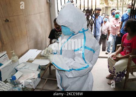 Les travailleurs de la santé dans les combinaisons PPE testent l'infection par Covid-19 en utilisant la méthodologie d'antigène rapide dans un hôpital gouvernemental rural lors de tests aléatoires sur des personnes dans le district de Parganas au nord 24 dans le sud du Bengale occidental, Inde sur 08 mai 2021. (Photo de Debajyoti Chakraborty/NurPhoto) Banque D'Images