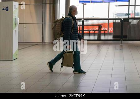 À l'intérieur du terminal de l'aéroport international d'Amsterdam-Schiphol pendant la pandémie de Covid-19. Le nombre réduit de passagers et l'équipage de conduite sont vus porter des équipements de protection comme les masques et les gants obligatoires, en gardant la distance entre eux pour éviter la propagation du coronavirus. Le nombre de passagers de l'aviation mondiale a diminué en raison des restrictions de voyage, des mesures de sécurité telles que les lockdowns, la quarantaine, la PCR et le test rapide avant les vols, pendant l'ère de la pandémie du coronavirus Covid-19 qui a durement frappé l'industrie de l'aviation et du voyage. Amsterdam, pays-Bas sur 4 mai 2021 (Phot Banque D'Images