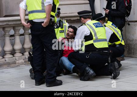 LONDRES, ROYAUME-UNI - 11 MAI 2021 : Les policiers arrêtent un manifestant lors d'une manifestation devant Downing Street contre l'escalade de violence déclenchée par les expulsions prévues de familles palestiniennes de leurs foyers par des colons juifs dans le district de Sheikh Jarrah à Jérusalem-est, le 11 mai 2021 à Londres, en Angleterre. Les tensions entre Israël et la Palestine se sont accrues ces derniers jours, des centaines de Palestiniens blessés lors d'affrontements avec les forces de sécurité autour de la vieille ville et à l'extérieur de la mosquée al-Aqsa à Jérusalem, suivis d'un échange de frappes aériennes par le Hamas et l'armée israélienne. (P Banque D'Images