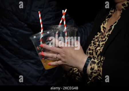 Une femme porte des tasses en plastique vides après une bonne boisson à l'extérieur d'un pub dans le centre de Dublin. Le jeudi 13 mai 2021, à Dublin, Irlande. (Photo par Artur Widak/NurPhoto) Banque D'Images
