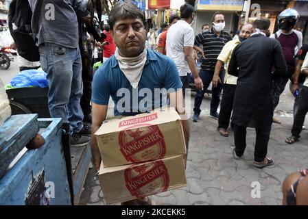 Un homme porte une boîte de bouteilles de liqueur achetées dans un magasin de liqueurs en cas d'urgence du coronavirus à Kolkata, en Inde, le 15 mai 2021. Selon un reportage médiatique indien, le gouvernement du Bengale occidental annonce un confinement de 16 mai jusqu'à 30 mai, dans le contexte d'une vague de Covid-19. (Photo par Indranil Aditya/NurPhoto) Banque D'Images