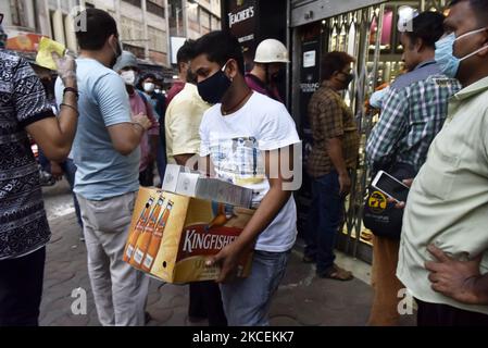 Un homme porte une boîte de bouteilles de liqueur achetées dans un magasin de liqueurs en cas d'urgence du coronavirus à Kolkata, en Inde, le 15 mai 2021. Selon un reportage médiatique indien, le gouvernement du Bengale occidental annonce un confinement de 16 mai jusqu'à 30 mai, dans le contexte d'une vague de Covid-19. (Photo par Indranil Aditya/NurPhoto) Banque D'Images