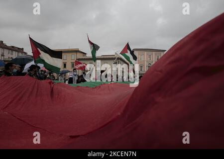 Des manifestants branding et agitant un immense drapeau palestinien à Pise, en Italie, sur 15 mai 2021. L'escalade entre Israël et la Palestine a conduit à une frappe aérienne transfrontalière au cours des derniers jours. Les membres de la communauté palestinienne et leurs partisans manifestent contre les actions d'Israël envers les Palestiniens à Gaza. 15 mai est également le jour où les Palestiniens commémorent Nakba pour se souvenir des quelque 700 000 000 Palestiniens qui ont été déplacés de leurs foyers après la formation d'Israël en 1948. (Photo par Enrico Mattia Del Punta/NurPhoto) Banque D'Images