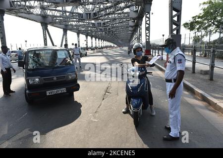 Un personnel de police contrôle un conducteur de motocycle sur 16 mai 2021 à Kolkata, Inde. Samedi, le gouvernement du Bengale occidental a annoncé un verrouillage complet dans tout l'État, de 16 mai à 30 mai. Il a également imposé un couvre-feu de nuit. (Photo de Sukhomoy Sen/NurPhoto) Banque D'Images