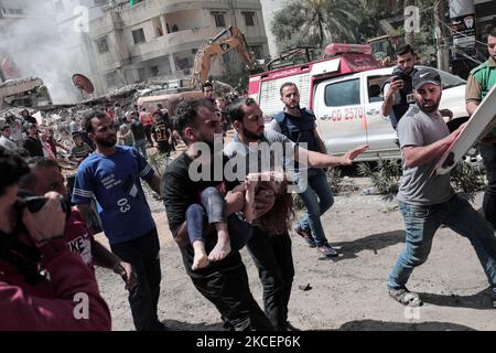 (NOTE AUX ÉDITEURS : l'image contient du contenu graphique.) Un palestinien évacue une petite fille des décombres d'une maison détruite après une attaque aérienne israélienne dans la ville de Gaza, le 16 mai 2021. Au total, 174 personnes ont été tuées dans des raids israéliens à Gaza, dont 47 enfants et 29 femmes (photo de Mamen Faiz/NurPhoto) Banque D'Images
