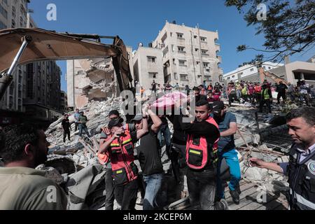 (NOTE AUX ÉDITEURS : l'image contient du contenu graphique.) Un palestinien évacue une petite fille des décombres d'une maison détruite après une attaque aérienne israélienne dans la ville de Gaza, le 16 mai 2021. Au total, 174 personnes ont été tuées dans des raids israéliens à Gaza, dont 47 enfants et 29 femmes (photo de Mamen Faiz/NurPhoto) Banque D'Images