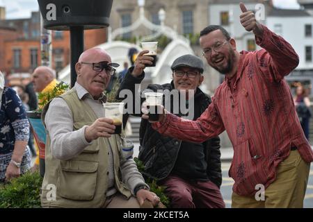 Les habitants de la région apprécient une pinte de Guinness dans une tasse en plastique près du pont Ha'Penny dans le centre-ville de Dublin. L'Irlande fait un nouveau pas vers la normalité, car tous les commerces de détail non essentiels sont autorisés à reprendre à partir d'aujourd'hui. Le lundi 17 mai 2021, à Dublin, Irlande. (Photo par Artur Widak/NurPhoto) Banque D'Images