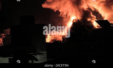 Une boule de feu explose au-dessus des bâtiments de la ville de Gaza alors que les forces israéliennes bombardant l'enclave palestinienne, au début de 18 mai 2021. - Les jets israéliens ont maintenu un barrage de frappes aériennes contre l'enclave palestinienne de Gaza, une semaine de violence qui a tué plus de 200 personnes, a poussé les dirigeants mondiaux à intensifier la médiation. (Photo de Mamen Faiz/NurPhoto) Banque D'Images