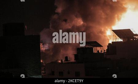 Une boule de feu explose au-dessus des bâtiments de la ville de Gaza alors que les forces israéliennes bombardant l'enclave palestinienne, au début de 18 mai 2021. - Les jets israéliens ont maintenu un barrage de frappes aériennes contre l'enclave palestinienne de Gaza, une semaine de violence qui a tué plus de 200 personnes, a poussé les dirigeants mondiaux à intensifier la médiation. (Photo de Mamen Faiz/NurPhoto) Banque D'Images