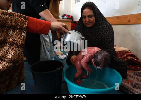 Une femme palestinienne assoit un bébé d'un jour dans un bool des Nations Unies où de nombreuses familles palestiniennes déplacées ont cherché refuge dans la ville de Gaza, dans le cadre de frappes aériennes et de bombardements des forces israéliennes sur 20 mai 2021. - Le bébé a été nommé d'après Mohammed Deif, le leader reclus de l'aile militaire du groupe islamiste palestinien Hamas. Israël et les Palestiniens sont embourbés dans leur pire conflit depuis des années alors qu'Israël livre la bande de Gaza avec des frappes aériennes et de l'artillerie, tandis que les militants du Hamas lancèrent des roquettes dans l'État juif. (Photo de Majdi Fathi/NurPhoto) Banque D'Images