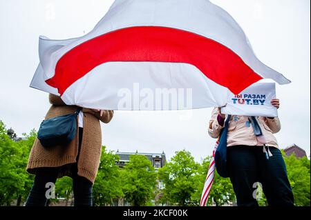 Deux femmes détiennent un drapeau biélorusse, lors d’une manifestation visant à mettre fin à la violence contre les prisonniers politiques en Biélorussie et en Russie qui a lieu à la Haye, sur 20 mai 2021. (Photo par Romy Arroyo Fernandez/NurPhoto) Banque D'Images