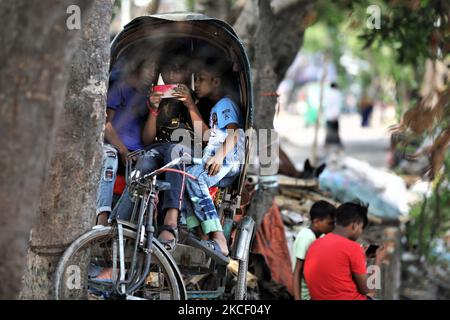 Les enfants jouent à des jeux sur les smartphones lorsqu'ils s'assoient dans un pousse-pousse à Dhaka, au Bangladesh, sur 20 mai 2021. (Photo de Syed Mahamudur Rahman/NurPhoto) Banque D'Images