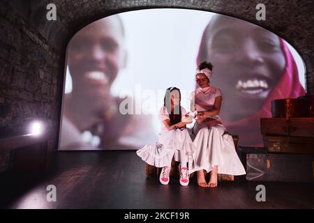 Saddhabh, une petite fille avec une colombe en papier rencontre Farah elle, une chanteuse libyenne-irlandaise, avec des images de la crise des réfugiés en arrière-plan, vue à l'intérieur d'EPIC le Musée irlandais de l'émigration à Dublin mercredi, 19 mai, dans le cadre du nouveau projet parallèle de paix d'Herstory, Lancement de la Journée mondiale de la diversité culturelle pour le dialogue et le développement. Des militants syriens, somaliens, kenyans et libyens ont pris part à un projet à Dublin qui raconte l'histoire des femmes et des filles de l'île d'Irlande dont la vie a été touchée par les guerres et les conflits sociaux. Le jeudi 20 mai 2021, à Dublin, Irlande. (Photo par Artur Widak/NurPh Banque D'Images